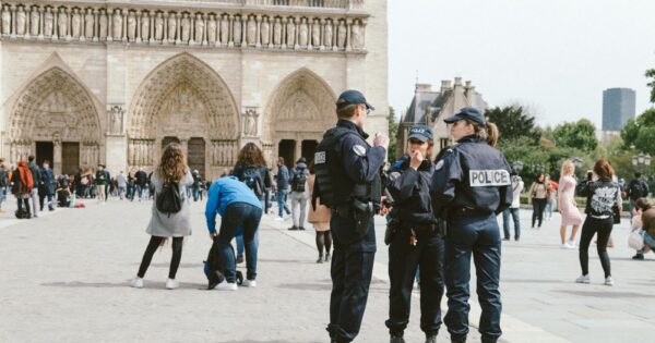 Police officers in uniform stand outside Notre Dame Cathedral in Paris.