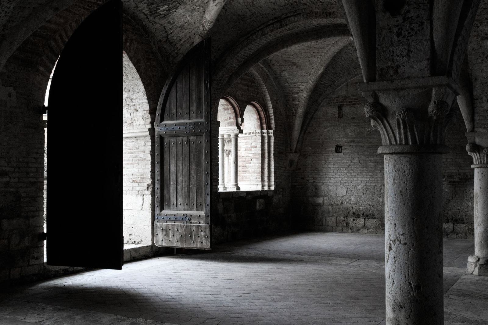 Intricately carved stone arches and columns in a Gothic-style abbey interior.