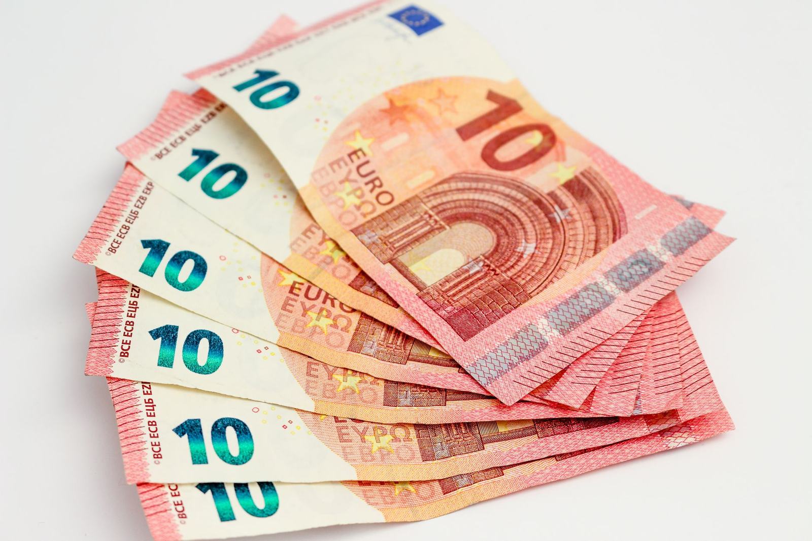 Close-up of a fan of 10 euro banknotes on a clean white background, showcasing European currency.