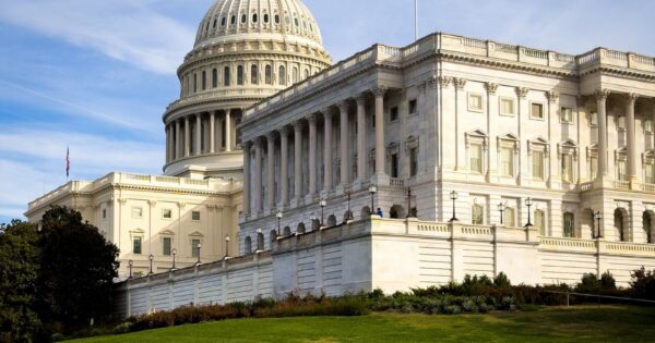 A picturesque view of the US Capitol Building in Washington, DC, under a clear sky.