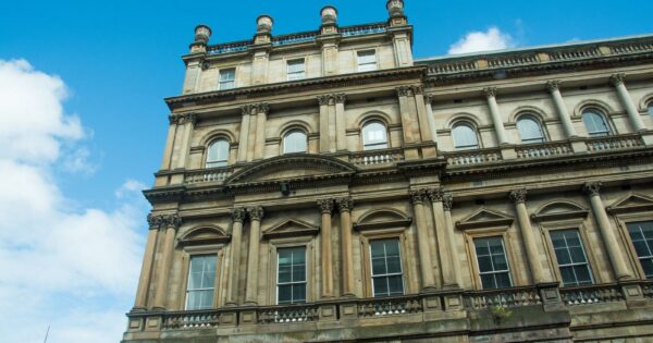 Elegant architectural facade of a historic building in Edinburgh on a clear day with blue skies.