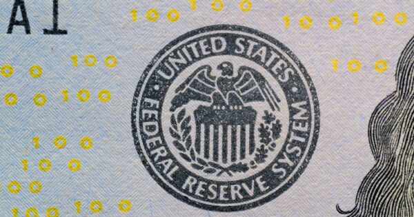 Detailed view of the US Federal Reserve System seal on currency with yellow digital numbers.