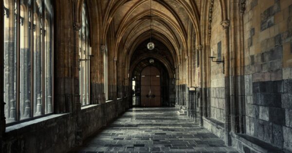 Explore the serene Gothic architecture of a cathedral hallway with elegant arches.