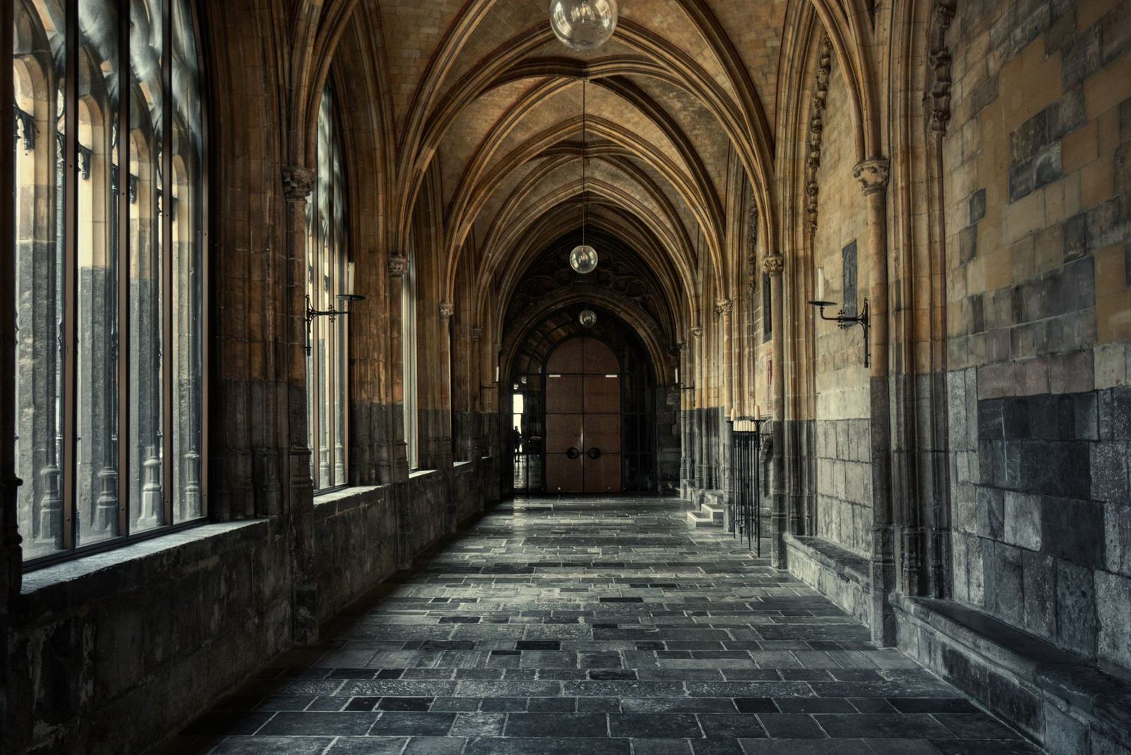 Explore the serene Gothic architecture of a cathedral hallway with elegant arches.