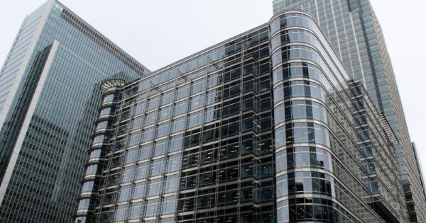 Low angle view of modern glass skyscrapers in an urban setting.