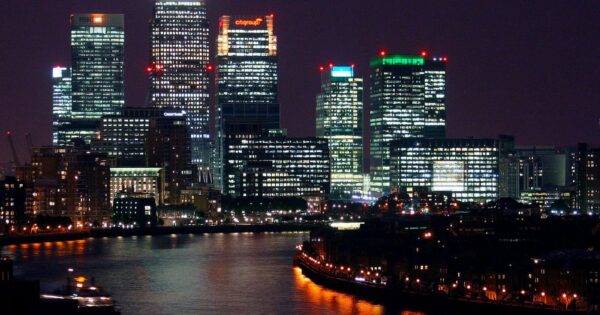 Beautiful nighttime view of Canary Wharf, London, with reflections on the River Thames.