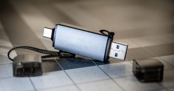 High-quality close-up of a dual USB-C and USB-A flash drive on a sleek grid-patterned background.