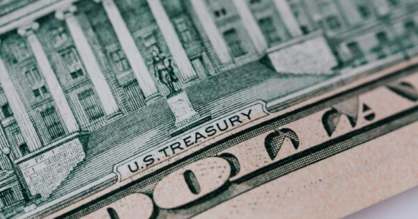 From above ten dollar banknote with inscription and United States treasury building placed on table