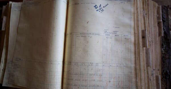 An open ledger book showing yellowing pages and handwritten entries, symbolizing the passage of time.