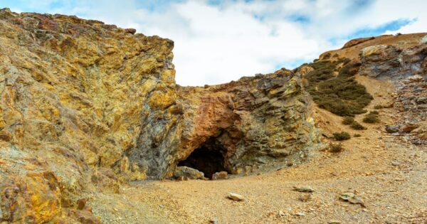 Explore the rugged terrain of Parys Mountain with its striking rocky cave and earthy tones.