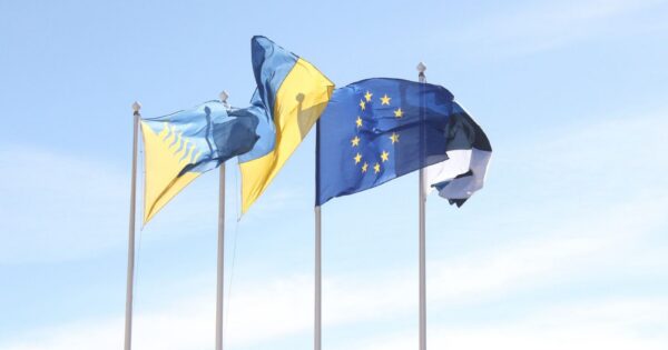 European Union and Estonian flags wave under a clear blue sky, symbolizing unity and harmony.