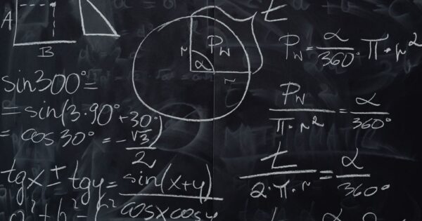 Complex trigonometric equations and geometric diagrams drawn on a classroom blackboard.