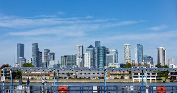 View of the iconic Canary Wharf skyline in London with blue skies and modern architecture.