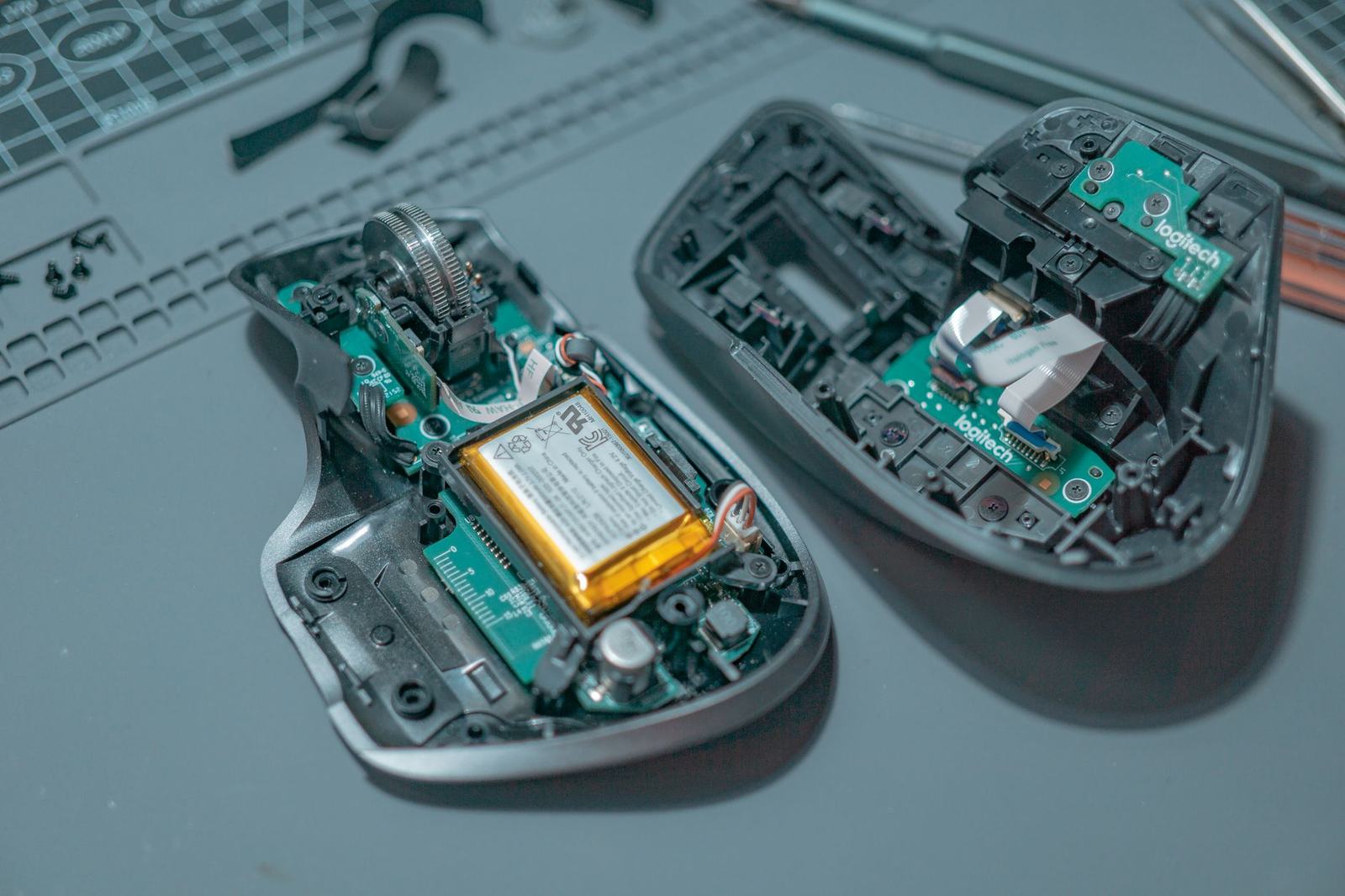Close-up of a disassembled computer mouse revealing internal circuit boards and components.
