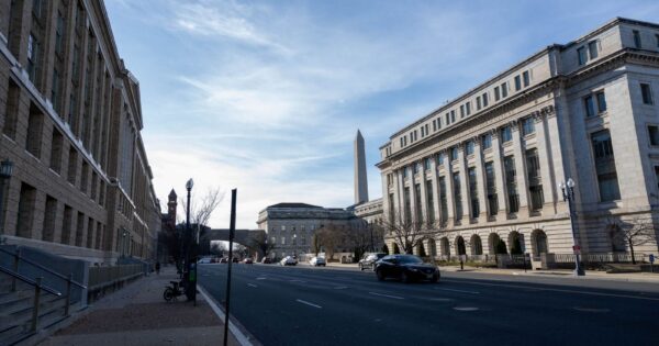 Street view in Washington DC featuring historic buildings and the Washington Monument.