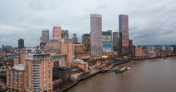 Aerial view of London's modern skyline and River Thames at dusk, showcasing urban architecture.