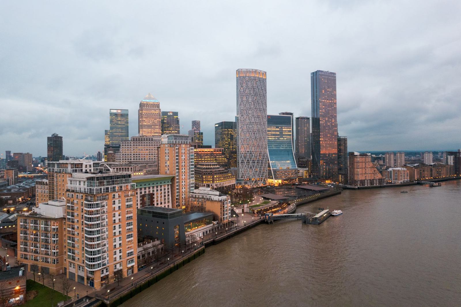 Aerial view of London's modern skyline and River Thames at dusk, showcasing urban architecture.